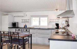 een keuken met witte kasten en een tafel en stoelen bij 2 Bedroom Gorgeous Home In Jmj in JÃ¤mjÃ¶