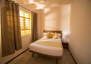 a small bedroom with a bed with a window at Cactus Hostel & Suites in Guanajuato