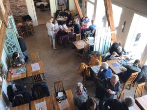 un grupo de personas sentadas en mesas en un restaurante en Mellomgården, en Norra Lundby