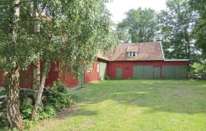 a red barn with a green garage at 4 Bedroom Nice Home In Slvesborg in Sandbäck