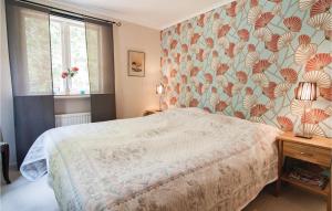 1 dormitorio con 1 cama y papel pintado con motivos florales en Amazing Home In Slite With Wifi en Åminne
