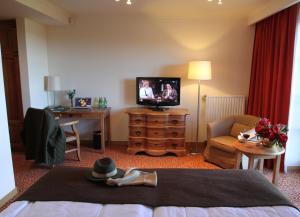 ein Hotelzimmer mit einem Bett und einem Flachbild-TV in der Unterkunft Hotel Zamek Bobolice in Bobolice