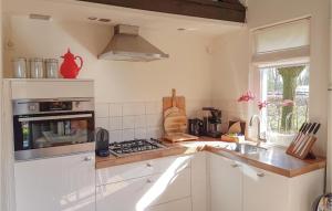 レーンデにあるLovely Home In Leende With Wifiの白いキャビネットとコンロ付きオーブンを備えたキッチン +11枚の写真