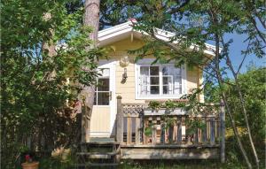a small yellow house with a wooden porch at Gorgeous Home In Sr With Kitchenette in Särö