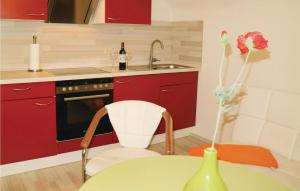 uma cozinha com armários vermelhos e uma mesa com um vaso em Nice Apartment In Nahetal-waldau With Wifi em Hinternah