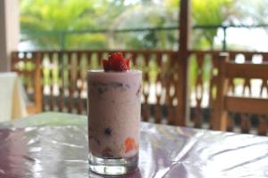 a drink with a strawberry on top of a table at La Casa Ucraniana in Canoa