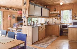 - une cuisine avec des placards en bois, une table et des chaises dans l'établissement Nice Home In Risr With 4 Bedrooms, à Nipe