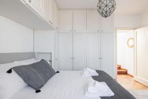 ein weißes Schlafzimmer mit einem Bett mit Handtüchern darauf in der Unterkunft The Great View in Rom
