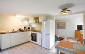 a kitchen with a white refrigerator and a table at Amazing Home In Stenkullen With 1 Bedrooms And Wifi in Stenkullen