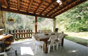 Une table et des chaises en bois sont disponibles sur la terrasse. dans l'établissement Awesome Apartment In Les Salles Du Gardon With 2 Bedrooms And Wifi, à Branoux-les-Taillades