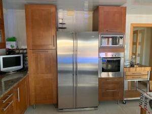 a kitchen with a stainless steel refrigerator and a microwave at Chalet moderno con PISCINA en Calafell in Calafell