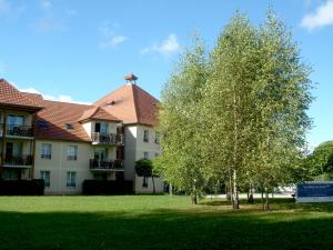 een gebouw met een boom ervoor bij Résidence VTF Les Allées du Green in Levernois