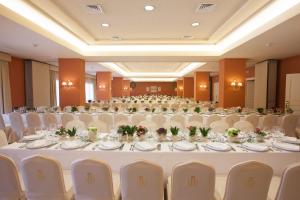 ロタにあるホテル ドゥケ デ ナヘラの白いテーブルと椅子が備わる大きな宴会場