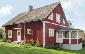 uma casa vermelha e branca com um banco à frente em Nice Home In Korsberga With Kitchen em Korsberga