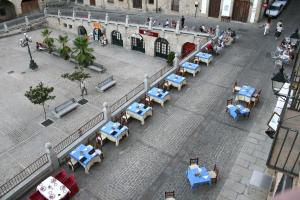 a city street filled with lots of tables and umbrellas at Alojamientos Plaza Mayor in Trujillo