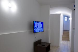 een woonkamer met een tv aan een witte muur bij Stairway to heaven in Bari