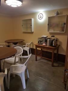 a restaurant with two tables and chairs and a table with a microwave at Hostel Buen descanso in Sucre