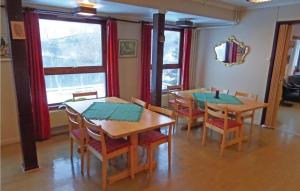 - une salle à manger avec 2 tables, des chaises et des fenêtres dans l'établissement Cozy Home In Korsfjorden With House A Mountain View, à Komagfjord
