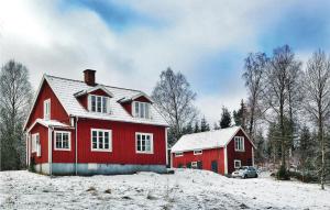 LidhultにあるBeautiful Home In Lidhult With 2 Bedrooms And Wifiの丘の上に雪屋根の赤い家