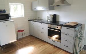 cocina con armarios blancos y fogones en Gorgeous Home In Hyltebruk With Lake View, en Hyltebruk