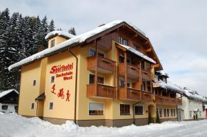 a large building with snow on the roof at Sporthotel Dachstein West in Annaberg im Lammertal
