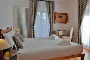 1 dormitorio con 1 cama blanca grande y escritorio en Hotel Roseg, en Chiesa in Valmalenco