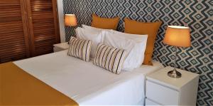 a bedroom with a bed with white sheets and pillows at Quinta Nova Vale Del Rey in Carvoeiro