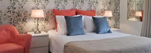 a bedroom with a bed with blue pillows and a chair at Quinta Nova Vale Del Rey in Carvoeiro