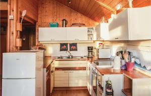 a kitchen with white appliances and a wooden ceiling at Cozy Home In Rendalen With House A Mountain View in Svarstad