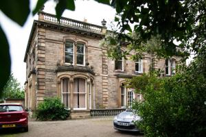 a house with two cars parked in front of it at Georgian House Boutique B&B in Edinburgh