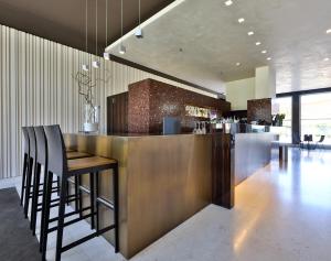 a lobby with a bar with stools and a bar counter at Best Western Plus Hotel Le Favaglie in Cornaredo