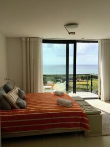 a bedroom with a large bed and a large window at ALYNES in Areia Branca