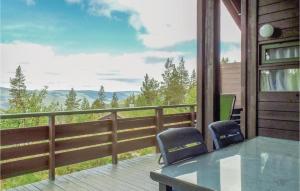a balcony with two chairs and a table and a view at Holiday Home Rendalen Renåfjellet Hylla in Svarstad