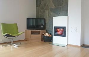 a living room with a television and a green chair at Four-Bedroom Holiday Home Farsund With Sea View 09 in Farsund +9 photos