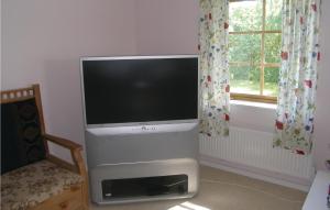 a flat screen tv in a living room with a window at Cozy Apartment In Saxtorp With Kitchenette in Saxtorp