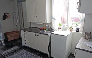 a kitchen with white cabinets and a sink and a window at Nice Home In Vxtorp With 2 Bedrooms in Floalt