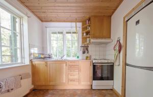 a kitchen with wooden cabinets and a window at Amazing Home In Kvicksund With 3 Bedrooms And Sauna in Kvicksund
