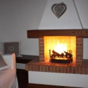 a brick fireplace with a fire in it at La Codarda country house in Pescosolido