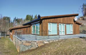 a house with a deck on a stone wall at Four-Bedroom Holiday Home Farsund With Sea View 09 in Farsund
