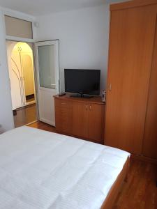 a bedroom with a bed and a flat screen tv at Apartament Melinda in Oradea