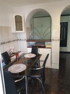 a kitchen with a table and chairs in a kitchen at Apartament Melinda in Oradea +15 photos