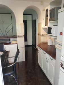 a kitchen with white cabinets and a table and chairs at Apartament Melinda in Oradea