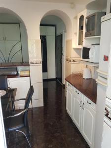 a kitchen with white cabinets and a table and chairs at Apartament Melinda in Oradea