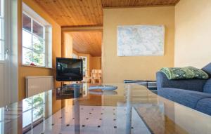 uma sala de estar com uma mesa de vidro e uma televisão em Lovely Home In Kvicksund With Sauna em Kvicksund