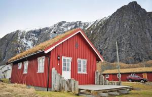 a red building with a mountain in the background at 3 Bedroom Lovely Home In Bstad in Unnstad