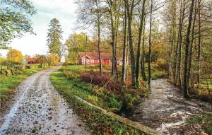 a dirt road in a field with a red house at Amazing Home In Hstveda With Wifi in Hästveda