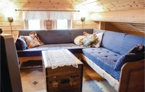 a blue couch in a living room with a table at Two-Bedroom Holiday Home In Sjusjoen in Sjusjøen