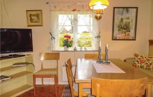 a dining room with a table and a television at Amazing Home In Hästveda With Wifi in Hästveda