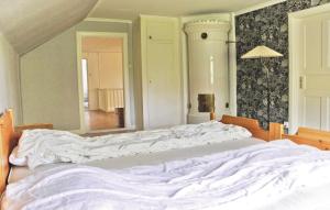 uma cama grande com lençóis brancos num quarto em Amazing Home In Vetlanda With 4 Bedrooms em Vetlanda