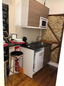 een kleine keuken met een wastafel en een fornuis bij Flor Liz in Lissabon
